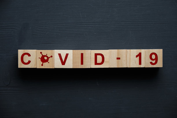 黑色背景和图标上刻有冠状病毒- COVID-19字样的木块。前视图。图片下载