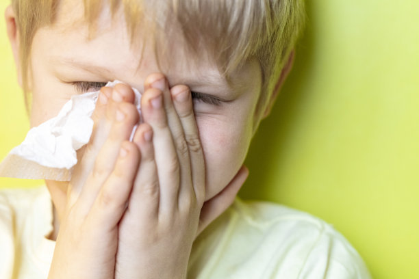 一个生病的男孩在擦鼻子图片下载