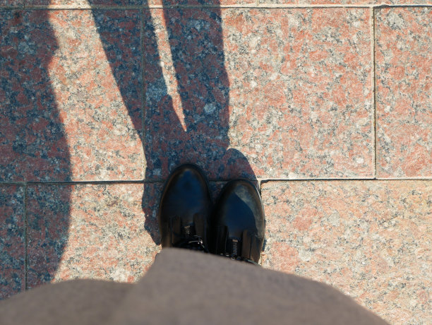 大理石石板上一个男人的影子。人在铺路板上的影子图片下载