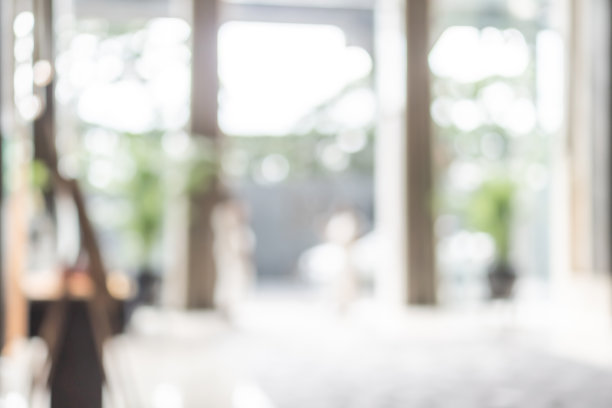 酒店或写字楼大堂的背景模糊的内部景观，面向接待大厅，现代豪华的白色房间空间与模糊的走廊和建筑玻璃墙窗户图片下载