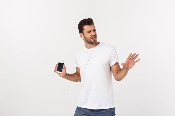 随意英俊的男人跳舞与手机孤立在白色的背景图片下载