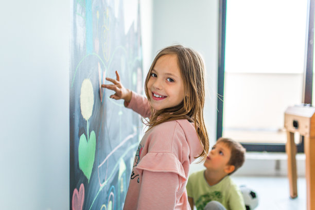 漂亮的小女孩在黑板上画画图片下载