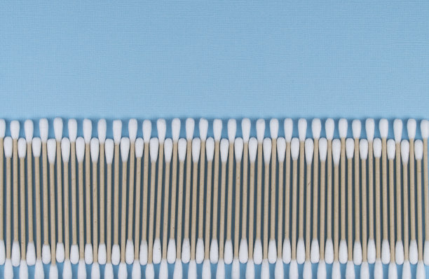 用棉签在蓝色背景上平铺合成。天然棉棒由棉花和甘蔗制成。图片下载