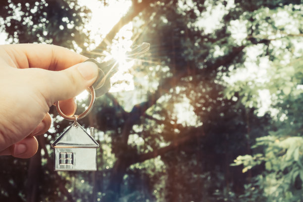 房屋模型和钥匙在房屋保险经纪人的代理或在销售人员手中。房地产中介提供房屋、财产保险和安全、经济适用房的概念图片下载