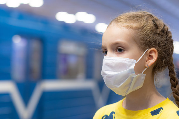 高兴、快乐、美丽快乐的孩子们戴着医疗保健护卫或保护口罩，穿着黄色t恤在地铁或地下大厅里图片下载