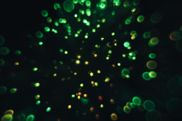 美丽的光学抽象绿色散景在黑暗的背景。图片下载