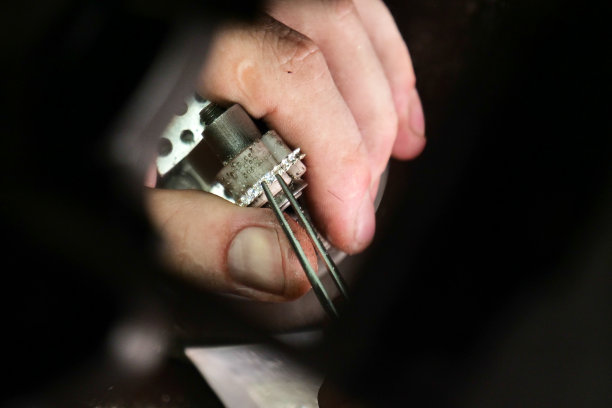 一个金匠的手使用金匠的工具制作金或银戒指或钻石的特写图片下载