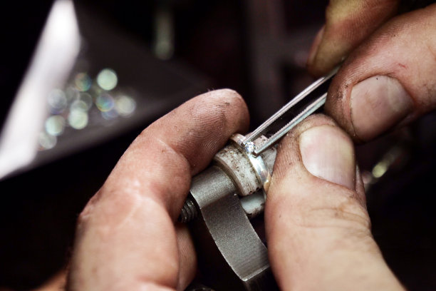 一个金匠的手使用金匠的工具制作金或银戒指或钻石的特写图片下载