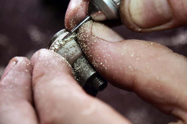 一个金匠的手使用金匠的工具制作金或银戒指或钻石的特写图片下载