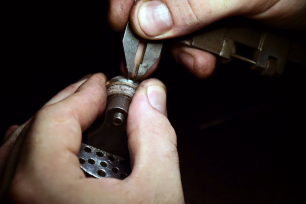 一个金匠的手使用金匠的工具制作金或银戒指或钻石的特写图片下载
