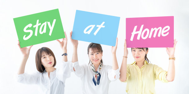 一群亚洲女性显示“呆在家里”的信息。图片下载