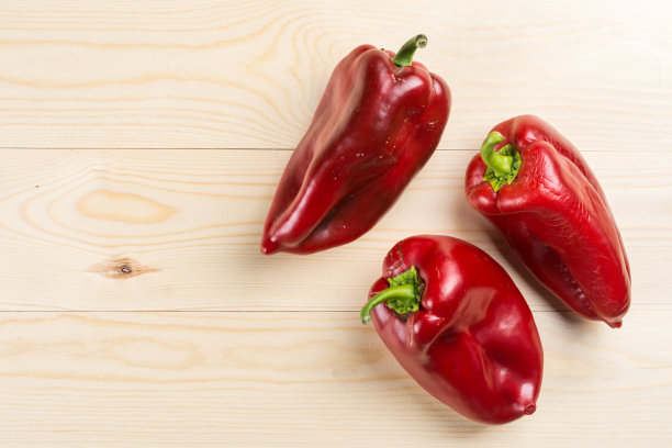 平铺在三个新鲜的红辣椒上面，有拷贝的空间图片下载