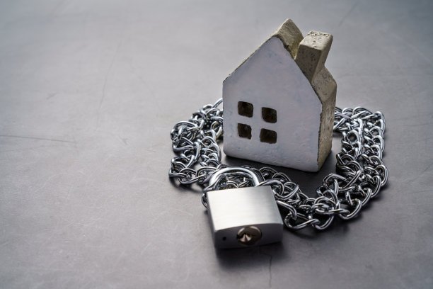 暗背景上的挂锁和微型房子图片下载