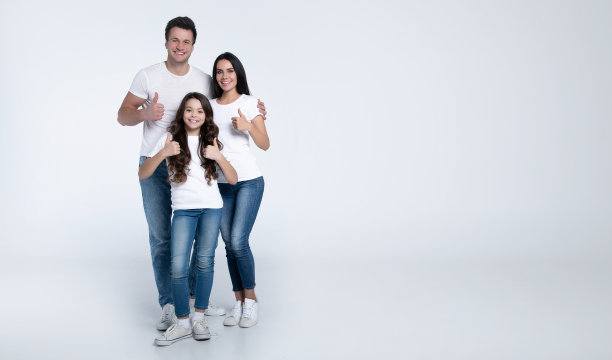 幸福美丽的年轻家庭在白色t恤，而他们拥抱彼此孤立在一个明亮的背景。图片下载