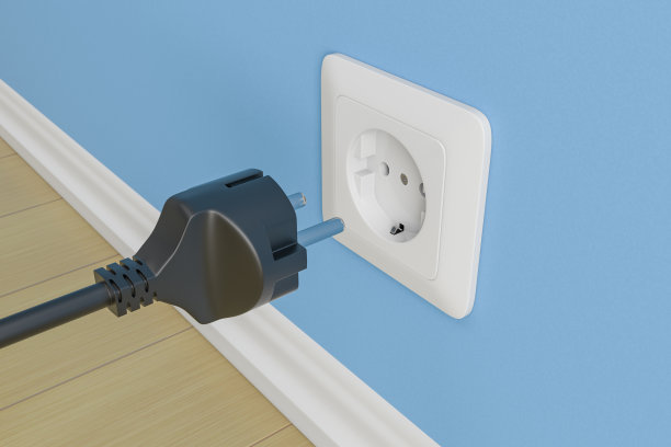 黑色电源插头，插座附近有电缆。蓝墙背景图片下载