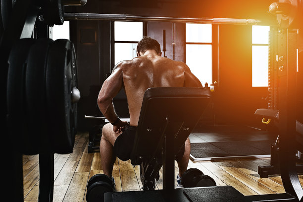 运动动机。健身房剧院。肌肉男健美者在健身房用哑铃做运动。运动的身体，健康的生活方式，健身动机，身体积极图片下载