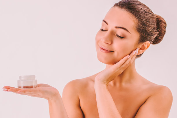 快乐的女人摆姿势用一罐面霜隔离图片下载