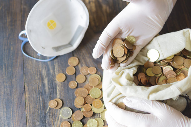 世界金融危机。手放保护手套，口罩，钱放在桌上。世界经济受到新冠肺炎疫情冲击图片下载