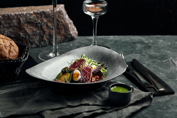 灰色的盘子上放着尼斯沙拉和金枪鱼。厨师的一道靓菜，食物照片，灰色背景，复制空间，传统法式菜肴图片下载