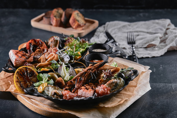盘子里的什锦海鲜。鱿鱼、虾、鲑鱼排和章鱼，搭配在海鲜餐桌上，非常漂亮。食物照片，低调，传统的意大利菜。俯视图，节省空间图片下载