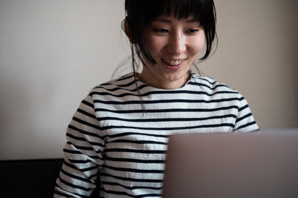 一个亚洲女人在用笔记本电脑开视频会议的照片图片下载