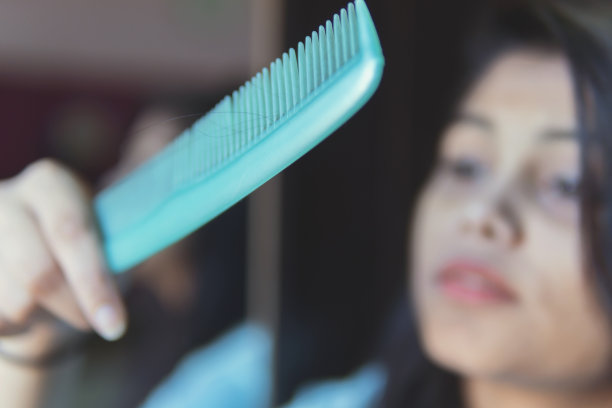 那个女孩因为掉头发而心烦意乱。图片下载