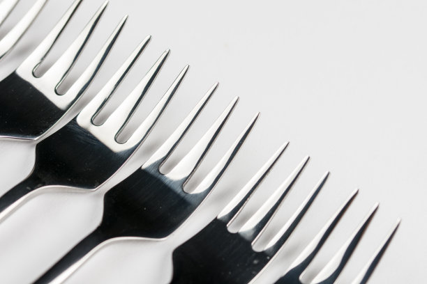 选择性聚焦特写宏金属闪亮叉排列在白色背景图片下载