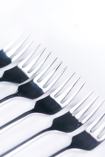 选择性聚焦特写宏金属闪亮叉排列在白色背景图片下载