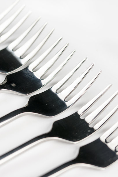 选择性聚焦特写宏金属闪亮叉排列在白色背景图片下载