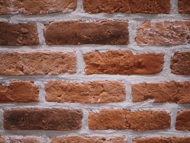 橙色砖外观。破石头纹理。石头墙。抽象的背景图片下载