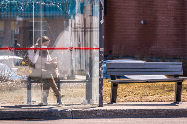 戴着口罩的女人在等车。图片下载