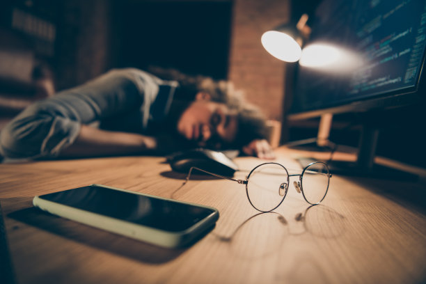 模糊的焦点照片漂亮的黑皮肤的商务女士在监视器附近睡着了加班期限规格电话躺桌子穿休闲衬衫坐晚上办公室在室内图片下载