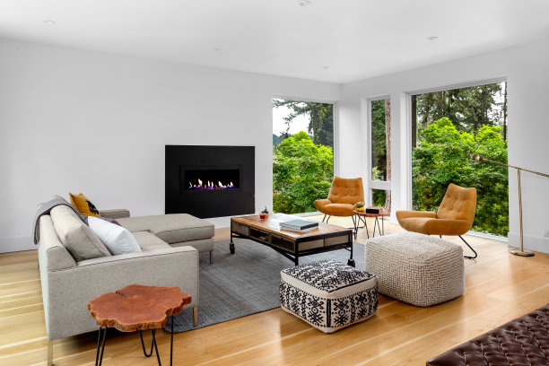 美丽的现代客厅室内硬木地板和壁炉在新的豪华的家。设有大窗户，可以看到树木和充足的自然光线。图片下载