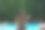 后视图放松在游泳池有一个果汁看着肩膀图片下载