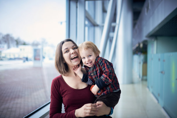 可爱的两岁男孩在公共场所散步时，妈妈的手图片下载