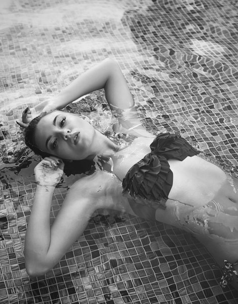 正上方的视图美丽的fit女人与比基尼躺在游泳池图片下载