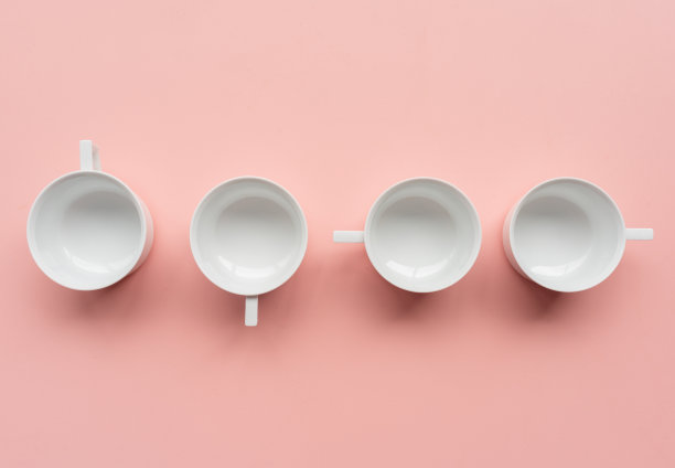 从上面看，粉色背景上有四个白色茶杯图片下载