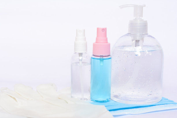 许多酒精凝胶瓶、面罩和医用手套隔离在白色背景上图片下载