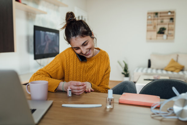 一名年轻女子在隔离期间染指甲并打电话聊天图片下载