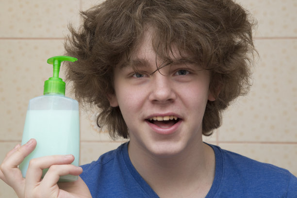 一个男人在浴室的水龙头下洗手。图片下载