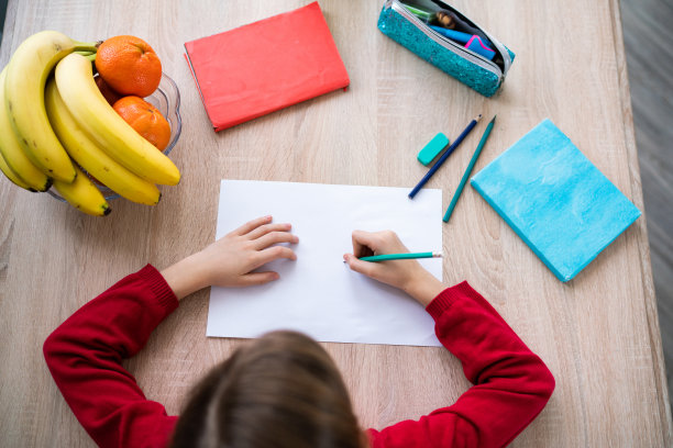 小女孩正在桌子上写字图片下载