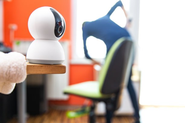 客厅保安摄像头，女佣在后台清洁-库存照片图片下载