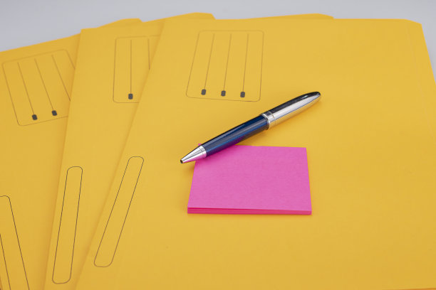 一支蓝色和银色的笔，上面有粉红色的荧光胶，上面是黄色文件夹，用来存档文件和文件图片下载