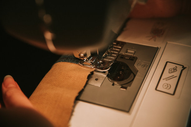 旧缝纫机，黑色的线剪刀和针，在一个破旧的工作台上。裁缝的工作表。纺织纺织或精细布料制作工业织物图片下载