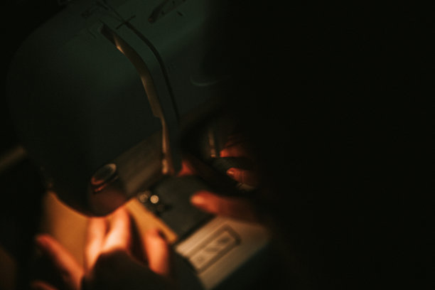 旧缝纫机，黑色的线剪刀和针，在一个破旧的工作台上。裁缝的工作表。纺织纺织或精细布料制作工业织物图片下载