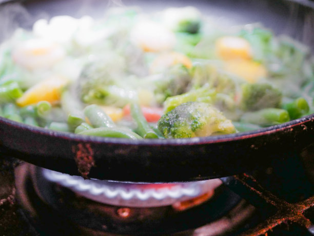 蔬菜在平底锅油炸特写。蒸汽来了。散焦。素食者几乎没有。生态食品图片下载