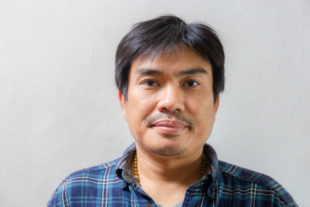 快乐的亚洲休闲男人微笑着，看着镜头与喜悦，幸福的概念图片下载