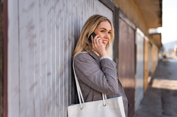 年轻女子使用移动电话交谈户外库存照片图片下载