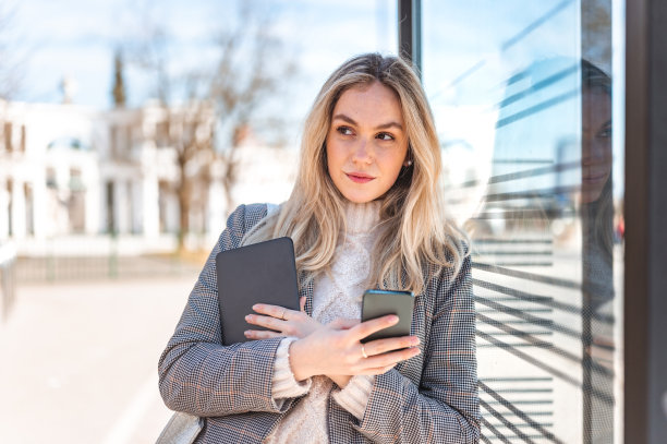 年轻女子使用手机和数码平板电脑户外库存照片图片下载