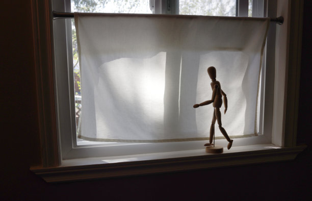 在窗台上漫步的木制艺术家形象图片下载